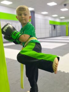 Young boy learning kickboxing in a safe, supportive martial arts class at Modern Martial Arts, developing confidence, balance, and coordination